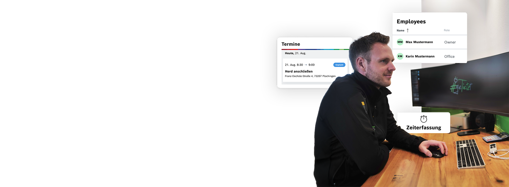 Ein Mann sitzt an einem Schreibtisch, nutzt einen Computer mit Monitor.