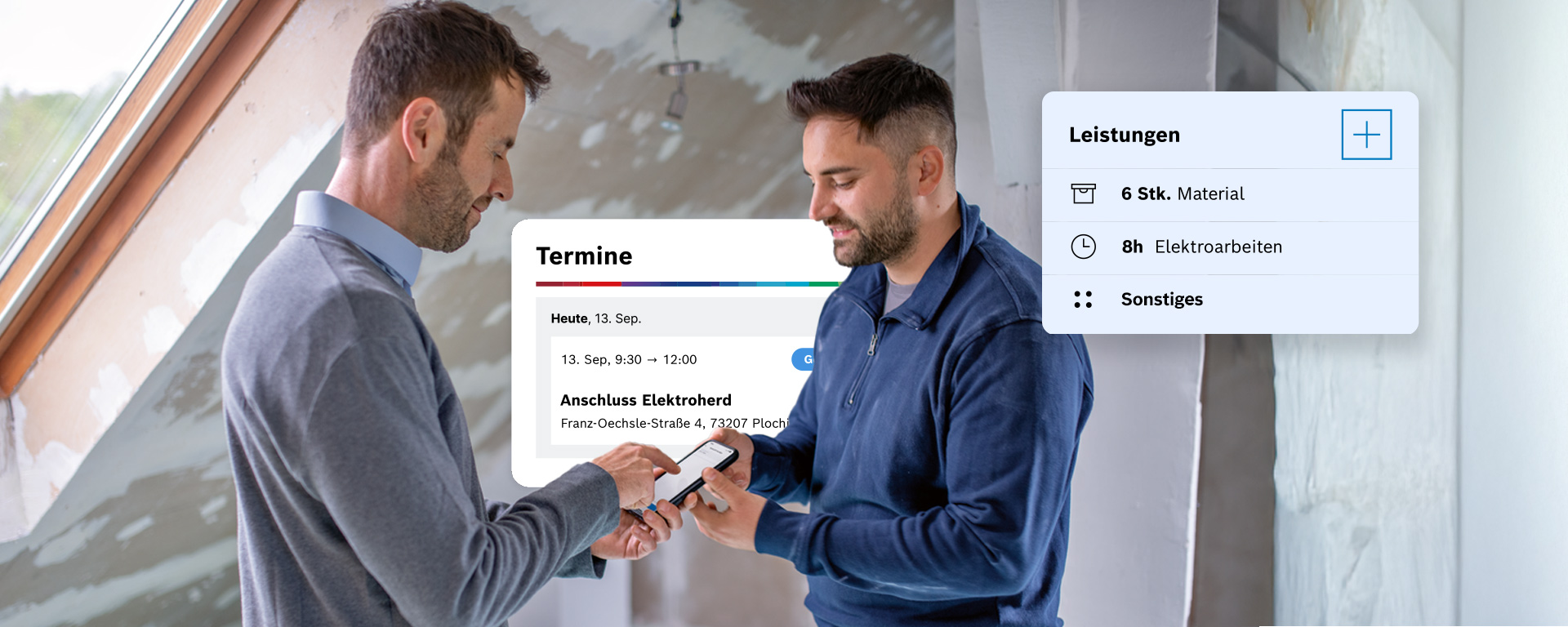 Zwei Männer, einer in grauem und der andere in blauem Pullover, diskutieren über ein Handy. Im Hintergrund sind unvollendete Wände und Fenster sichtbar.