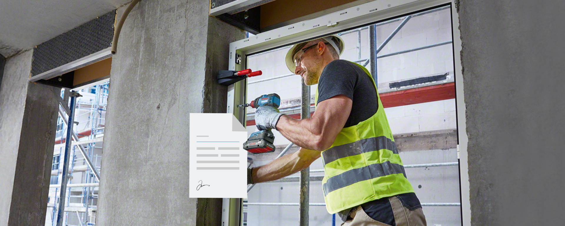 Ein Handwerker mit gelber Weste und Helm montiert ein Fenster mit einem Akkuschrauber in einer Baustelle.