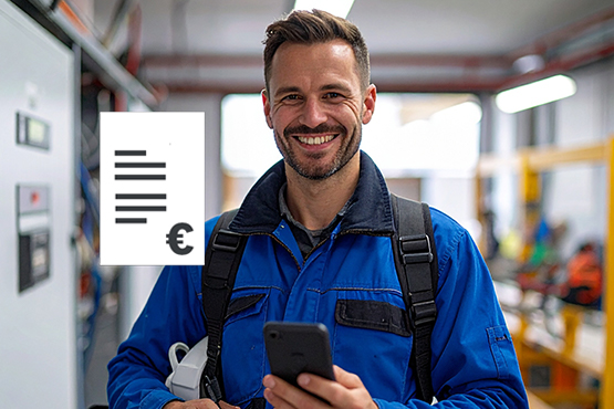 Mann in blauer Arbeitskleidung lächelt, hält Smartphone und steht in einer Werkstatt.