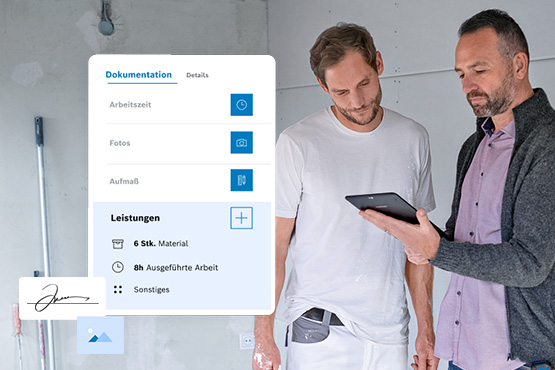 Zwei Handwerker besprechen Dokumentation auf einem Tablet in einem unvollendeten Raum mit grauen Wänden.